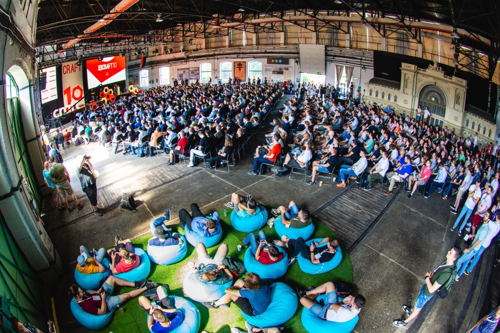 A photo from high up within the hall that was used as the main stage area. The hall is full of conference attendees watching the opening ceremony of the conference.